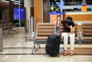 frau wartet genervt am Flughafen